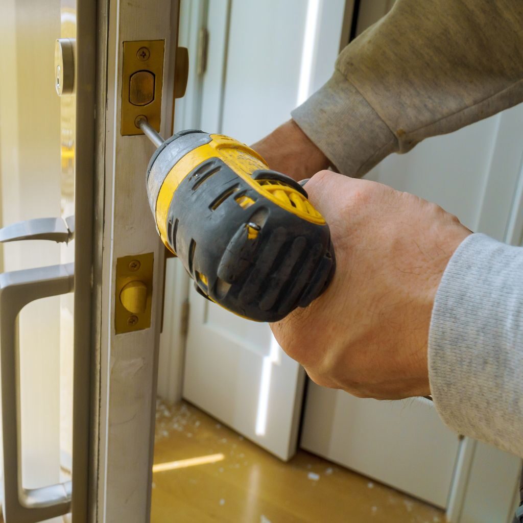 Monteur installeert een nieuw deurslot met boormachine