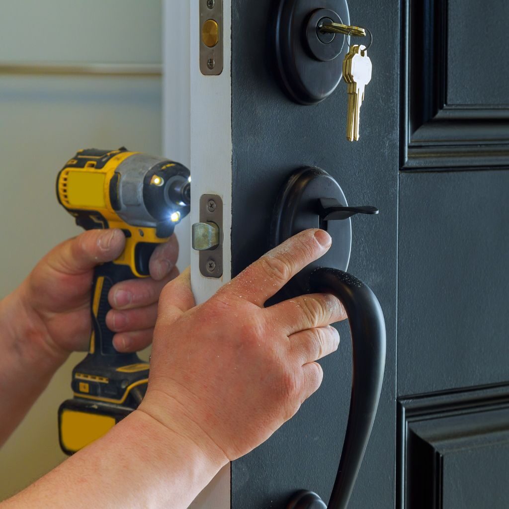 Professionele slotenmaker die een modern deurslot installeert met elektrisch gereedschap